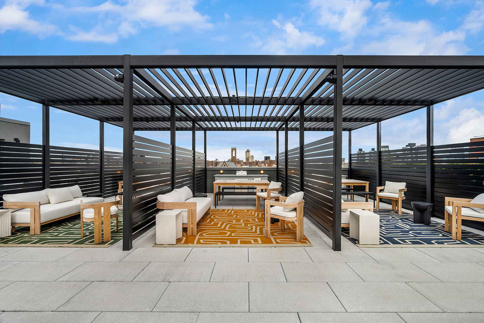 Rooftop terrace with ample open space, featuring grills and areas for gatherings that overlook NYC at 1975 Madison Ave.